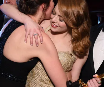 Two people hugging closely, with one holding an award.