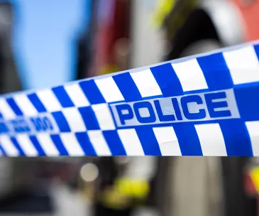 Blue and white police tape with the word "POLICE" in bold letters, slightly blurred background.