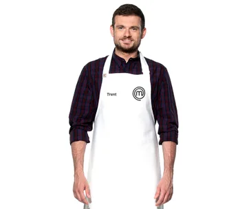 Trent from MasterChef Australia wearing a white apron with a MasterChef logo and a plaid shirt, smiling.