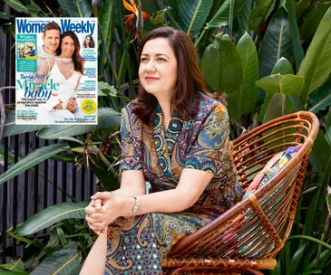 Outdoor portrait of a woman sitting on a chair, beside a magazine cover.