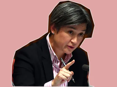 A person speaks assertively, holding a pen and gesturing near a microphone, cut-out style on a pink background.