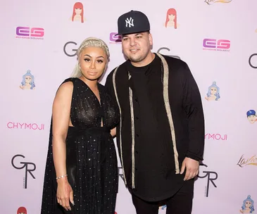 Celebrity couple posing at a Chymoji event with branded background.
