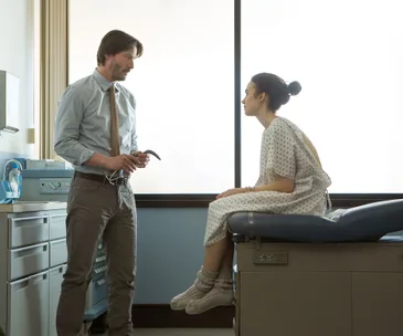 Doctor and patient in a clinic room from "To the Bone."