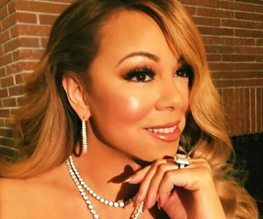 Close-up of a woman with long hair, wearing diamond jewelry, smiling slightly to the side.