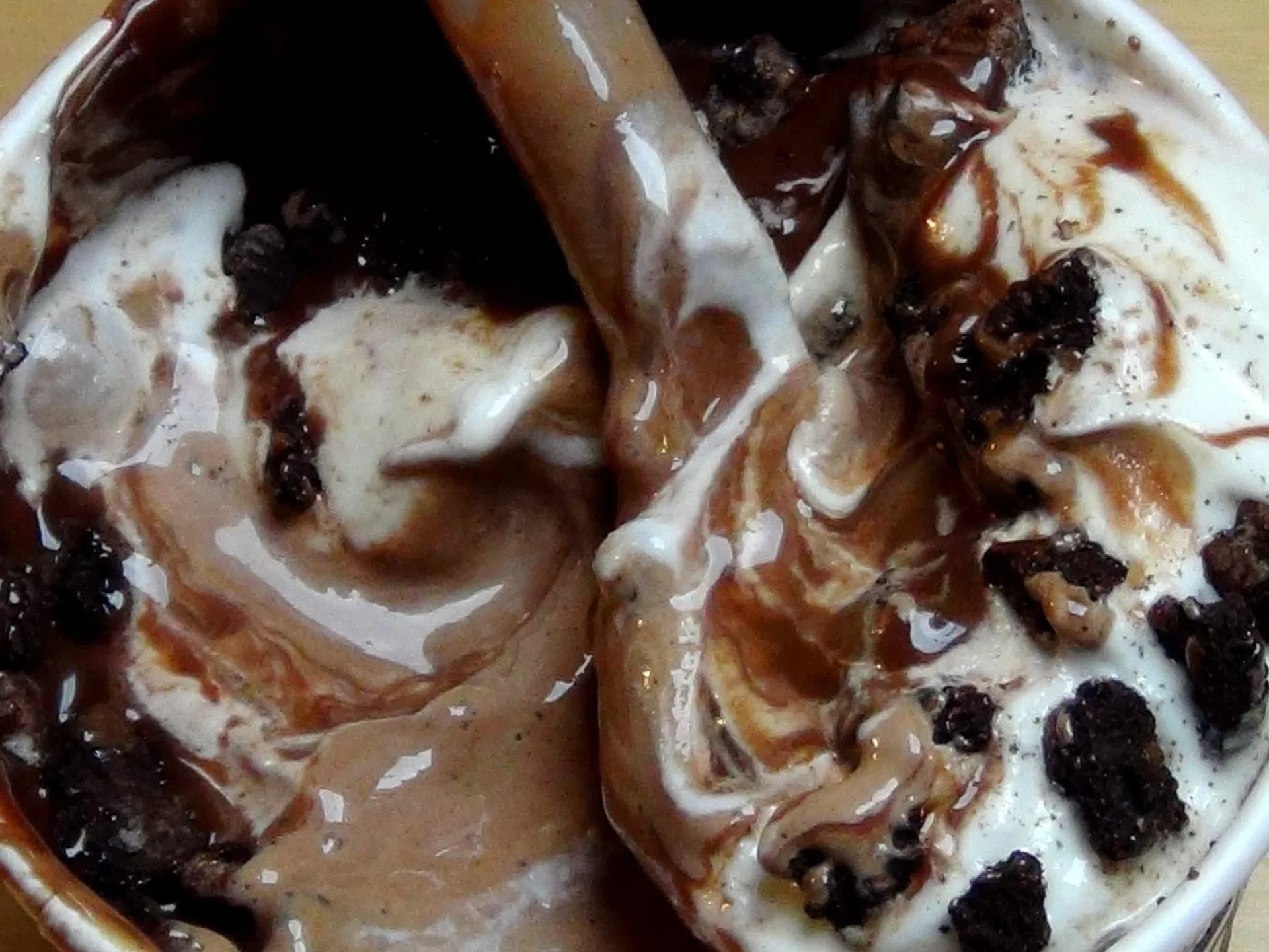 Close-up of a McFlurry with swirls of ice cream, chocolate sauce, and cookie crumbles.