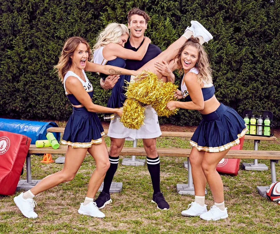 Group photo from Bachelor Australia 2017: four people in cheerleading outfits, playful pose with pom-poms.