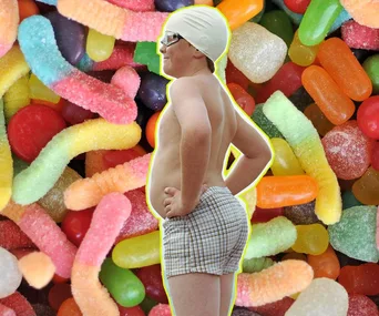 Overweight child in swim cap and goggles stands against colorful candy background.