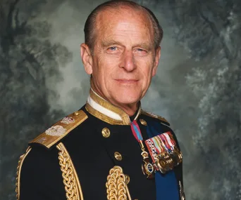 A man in formal military attire with medals, standing against a textured background.