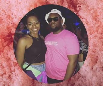 Two people posing together; one wearing sunglasses and a pink shirt, the other in a black top with a colorful jacket tied.