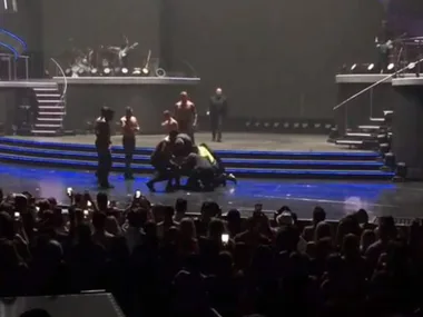 Security intervenes on stage during a Britney Spears Las Vegas concert as the audience watches.