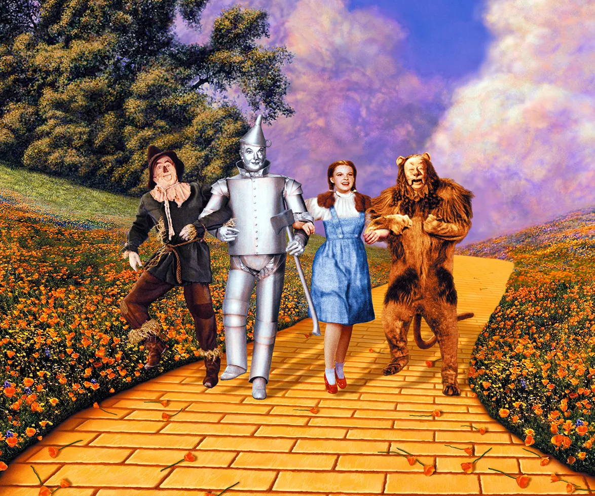 Characters from "The Wizard of Oz" on the yellow brick road: Scarecrow, Tin Man, Dorothy, and Cowardly Lion.