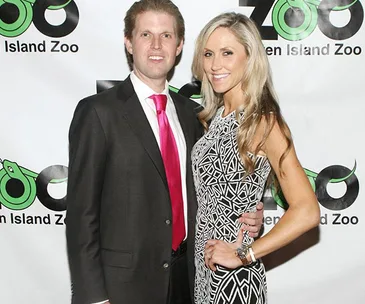 A couple dressed formally posing in front of a "Staten Island Zoo" backdrop.