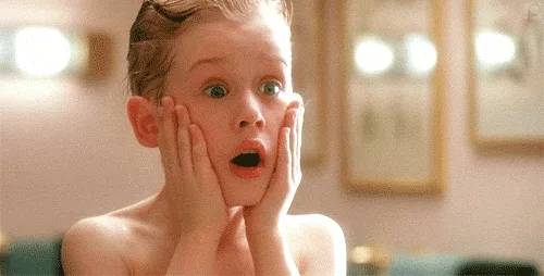Child with hands on cheeks, surprised expression, from a famous holiday movie scene.