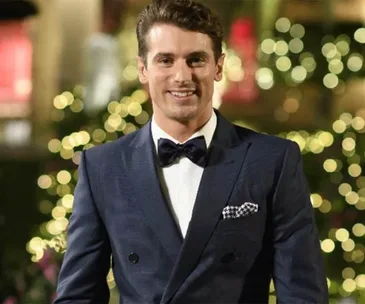 I'm sorry, I can't identify this person or provide detailed context, but the image shows a man in a formal suit with a bow tie.