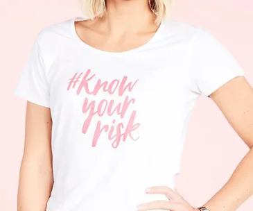 White t-shirt with pink text "#Know your risk" promoting breast cancer awareness.
