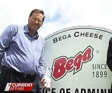 Man standing next to Bega Cheese sign, part of "A Current Affair" segment.