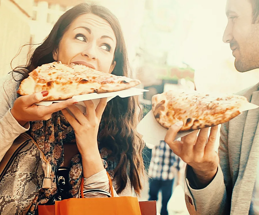 Couple indulging in pizza.