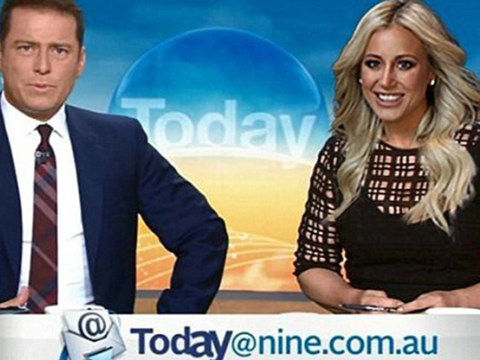 Two people seated at a news desk in the "Today" show studio, with a bright sunrise graphic in the background.
