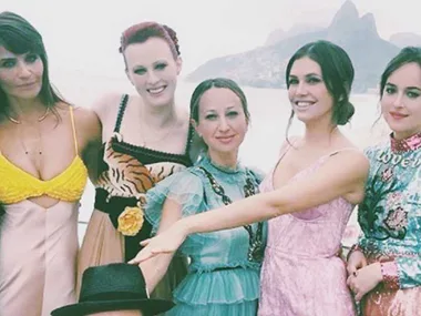Group of women posing together at a wedding with scenic mountains in the background.