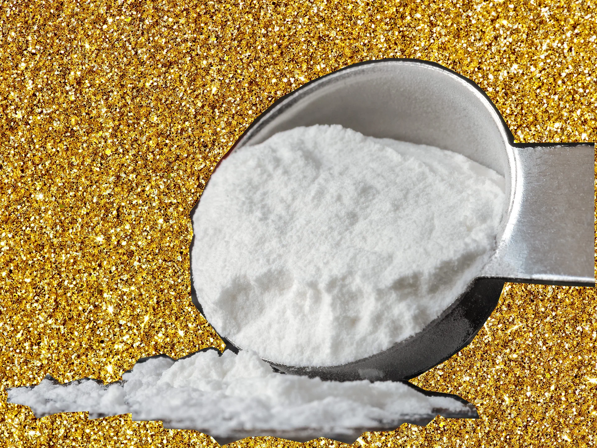 Scoop of baking soda against a gold glitter background.