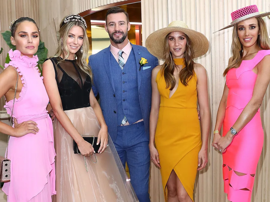 "Group at Melbourne Cup 2017 in colorful dresses and suits, with hats and accessories."