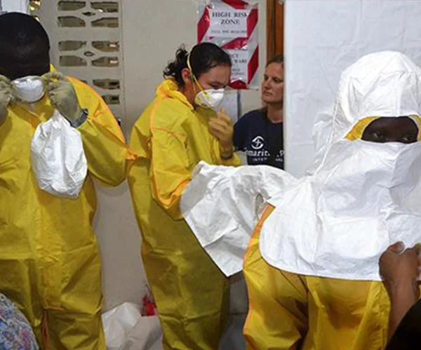 Healthcare workers in yellow protective suits and masks in a high-risk Ebola zone.
