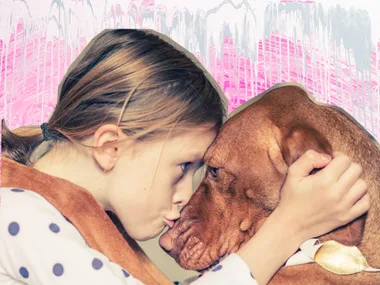 A girl lovingly presses her forehead against a brown dog's head, with a colorful background.