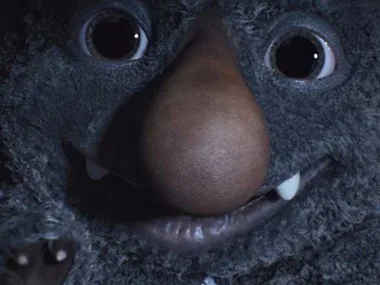 Close-up of a friendly grey monster with big eyes and a large nose from the John Lewis Christmas advert.