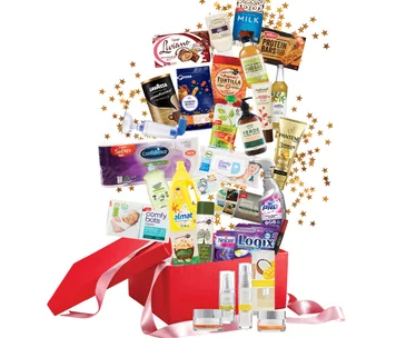Red gift box with assorted household and food products, surrounded by gold stars.