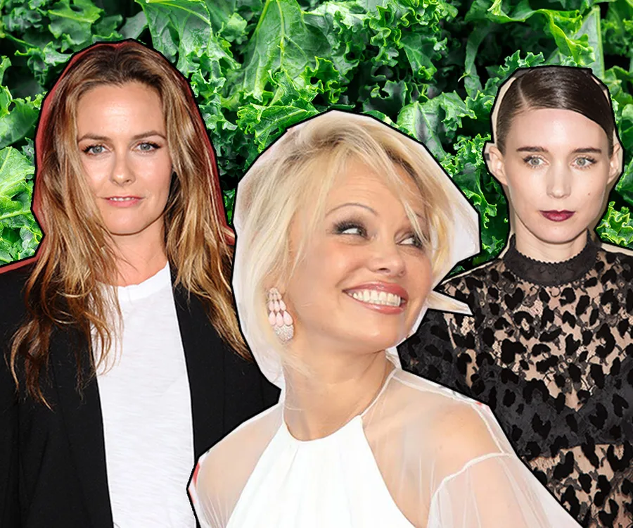 Three women posing in front of a background of kale leaves.