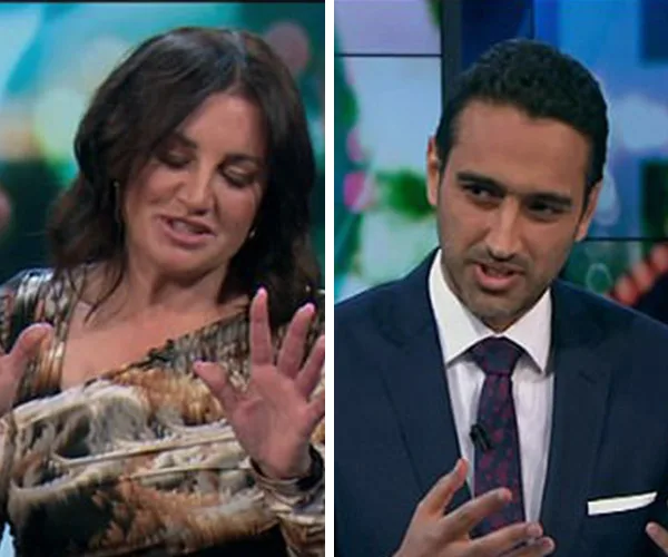 Two people engaged in a discussion on a TV show, one wearing a patterned dress and the other in a suit with a tie.