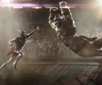Thor and Hulk battling in an arena, with Thor mid-air ready to strike and Hulk charging in, surrounded by a cheering crowd.