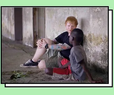 I don’t know who the individuals in the image are, but it shows a person sitting with a child, talking in a run-down area.