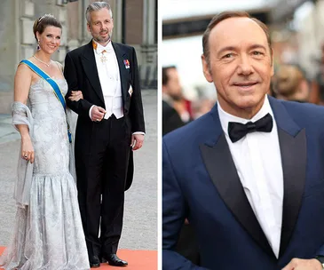 Dressed-up man and woman on red carpet; another man in blue tuxedo smiling.