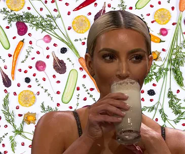 Woman with a smoothy, colorful vegetables in the background.
