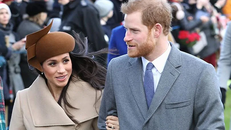Couple walking outdoors, smiling, with people in the background.