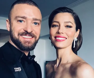 Two people dressed glamorously, smiling in a selfie before a formal event.