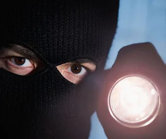 masked man holding a torch 