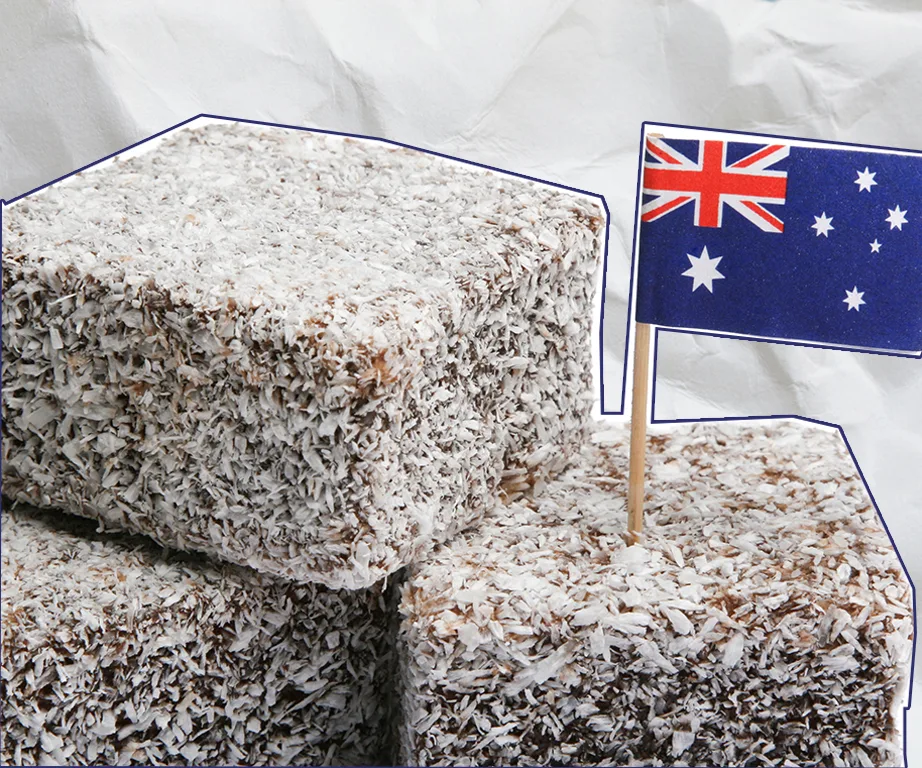 Lamingtons topped with shredded coconut, with an Australian flag toothpick inserted for decoration.