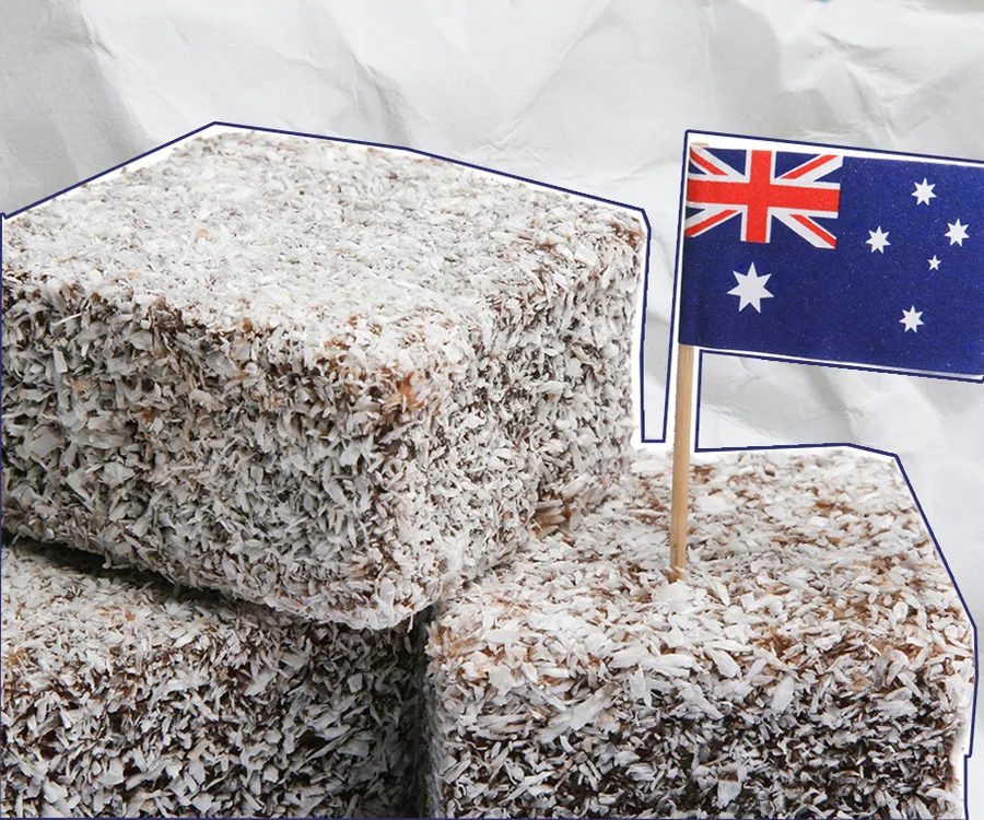 Lamingtons topped with shredded coconut, with an Australian flag toothpick inserted for decoration.