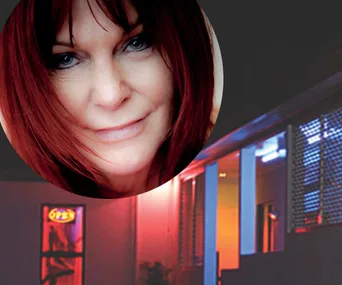 Headshot of a woman with red hair overlaid on a building with neon lights at night.