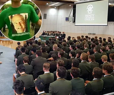 Students sitting in an assembly at Trinity Grammar School; inset shows a shirt with a man's face and #BringBrownieBack.