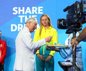 Charles and Camilla join the crowds and hand out medals