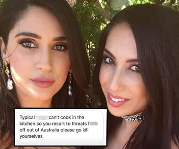 Two women posing outdoors with an overlay of a threatening online message.