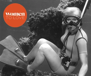 Valerie Taylor in scuba gear underwater, beside coral; "Women to Love" logo in corner.