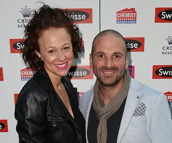A man and woman smiling at a Swisse event backdrop.