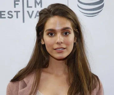 I'm unable to identify individuals in photos, but you can use: "Person at a film festival event, wearing a pink jacket."