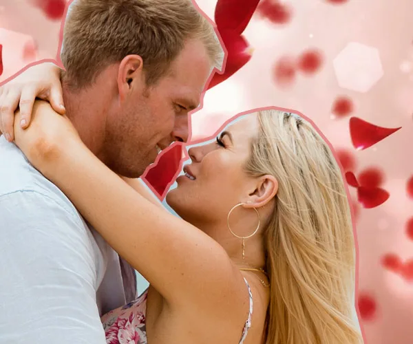 Man and woman embracing with rose petals in the background.