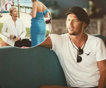 A man in a white shirt and cap sits on a sofa. Inset shows him kneeling, holding a ring, in a beach setting.