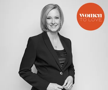 Leigh Sales in a black blazer, smiling with "women to love" logo in the corner.
